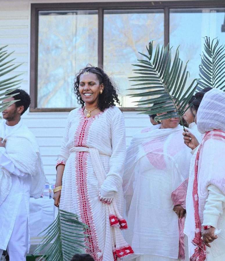 Woman smiling, holding palm branches with the group