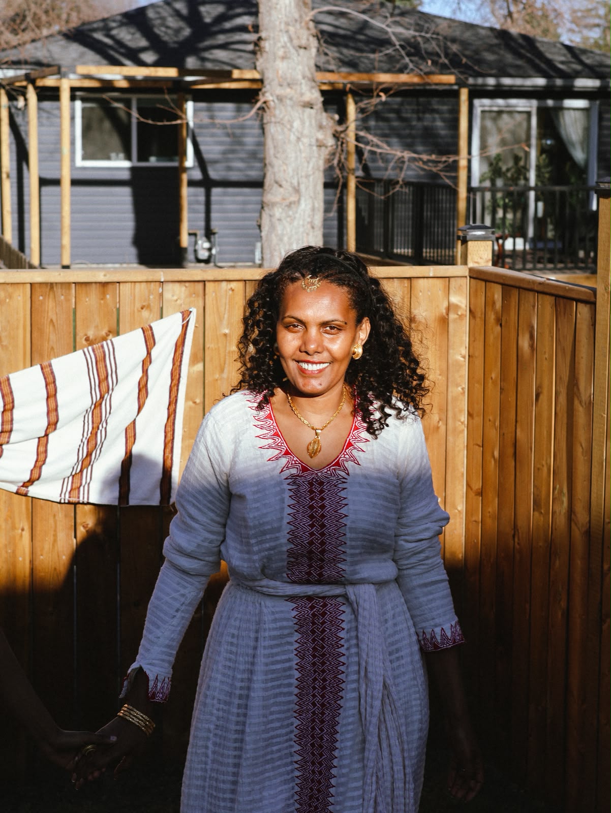 Woman in a woven blue and red embroidered dress smiling