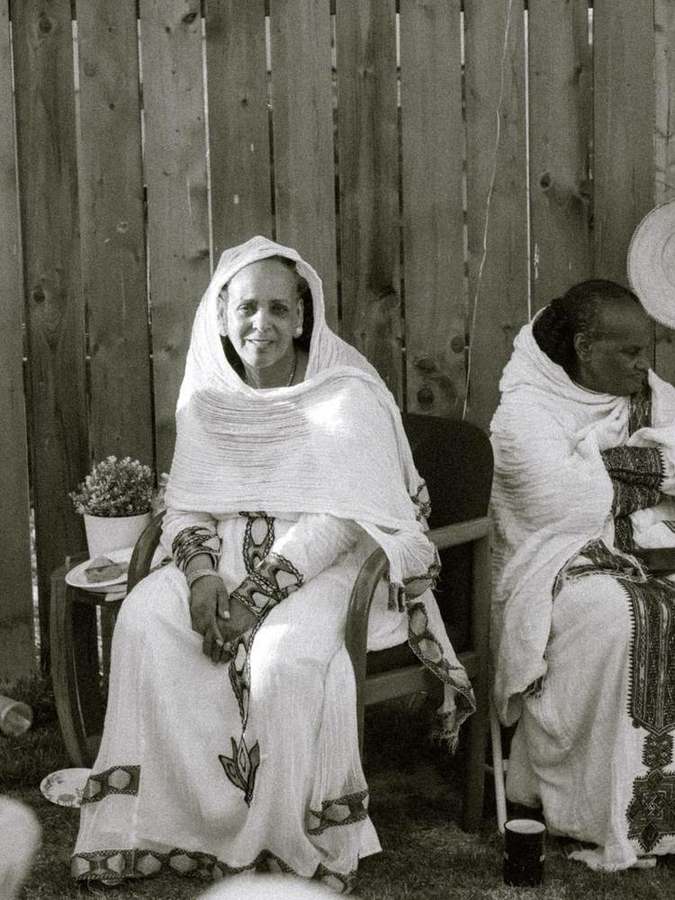 Elder woman seated, smiling warmly