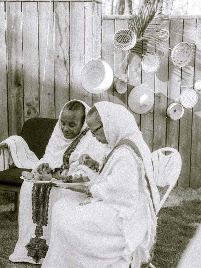 Two elder women sharing a plate of food