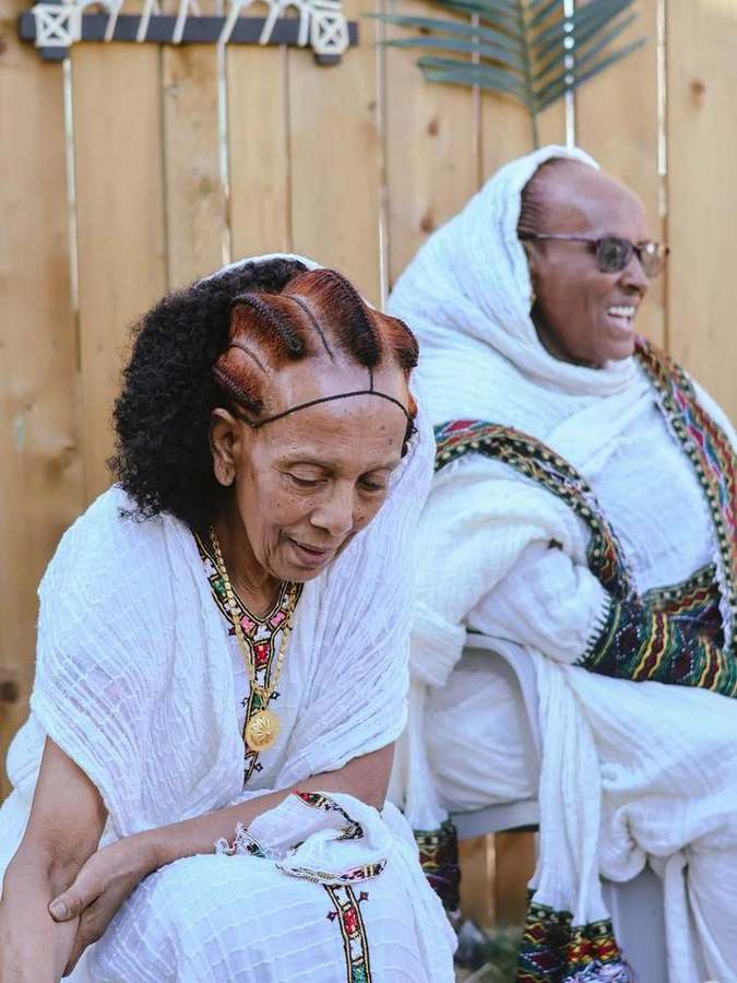 Two elder women sharing a laugh during the coffee ceremony