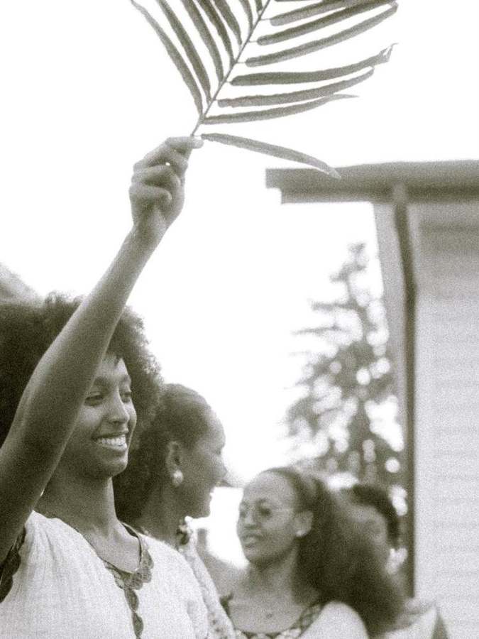 Woman raising a palm branch, smiling
