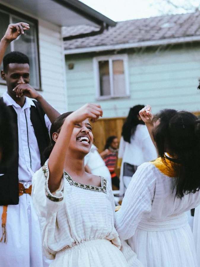 Woman dancing with raised arms, laughing